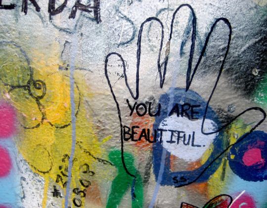 Eine bunte Graffiti-Wand, auf der steht: You are beautiful. Sag das ruhig zu dir, um deine Schreibblockade zu lösen. 