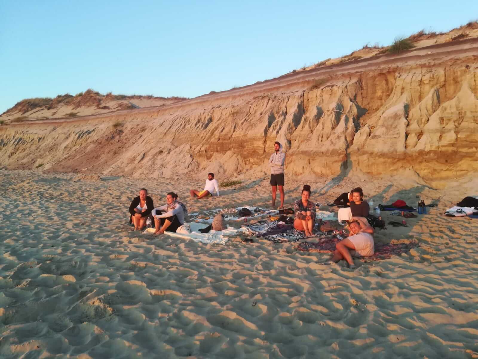 Die SEO Texterin mit Freund*innen am Strand im Sonnenuntergang. 