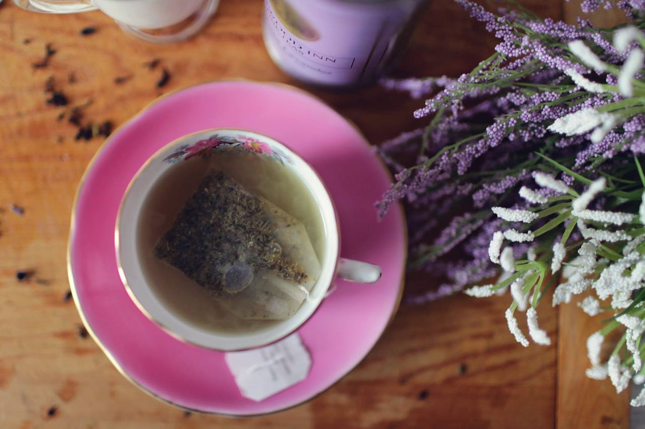 Für ein achtsames Leben steht diese dampfende Teetasse. Sie ist auf einem Holztisch, neben ihr Lavendel.